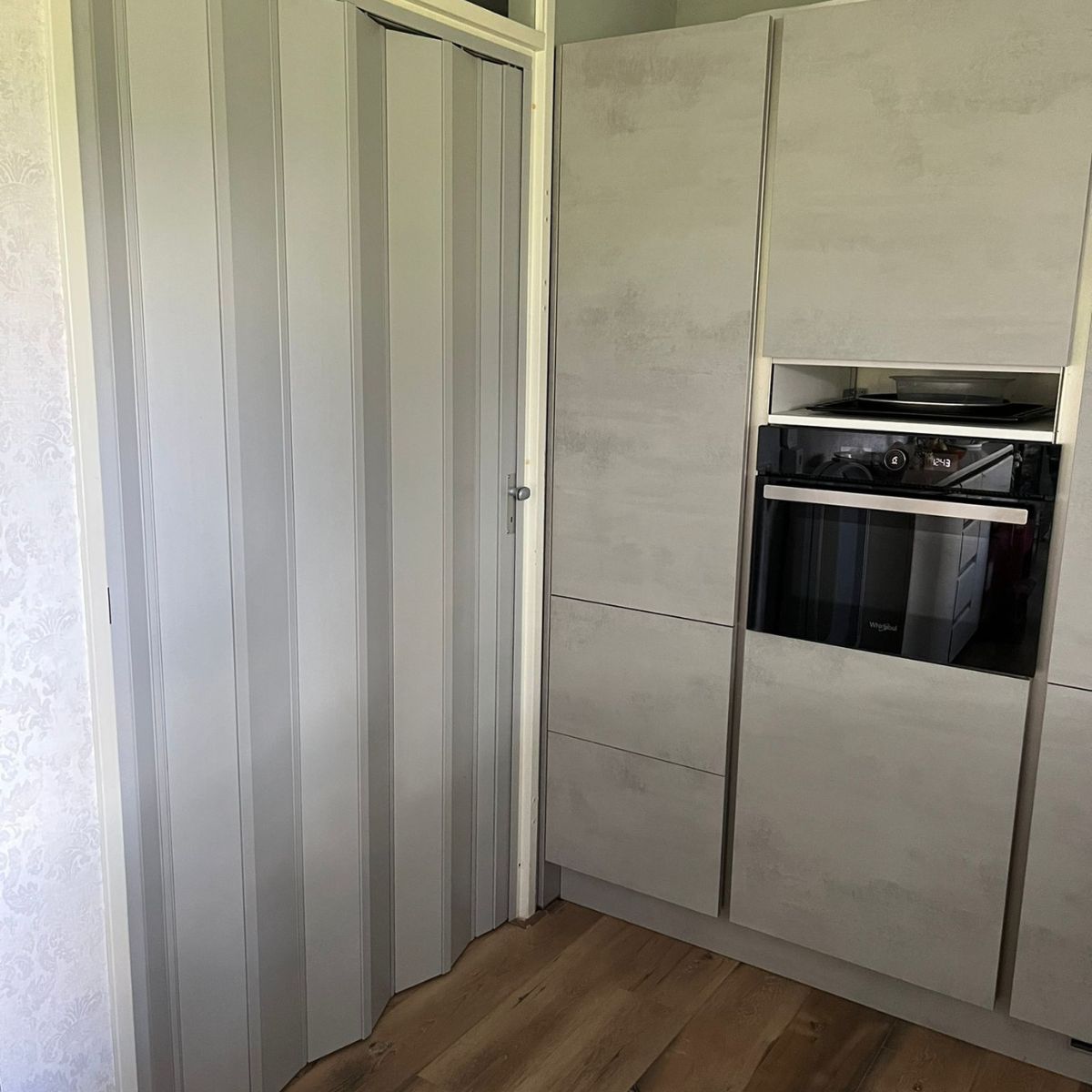 Stijlvolle grijs vouwdeur als entree tot een slaapkamer.